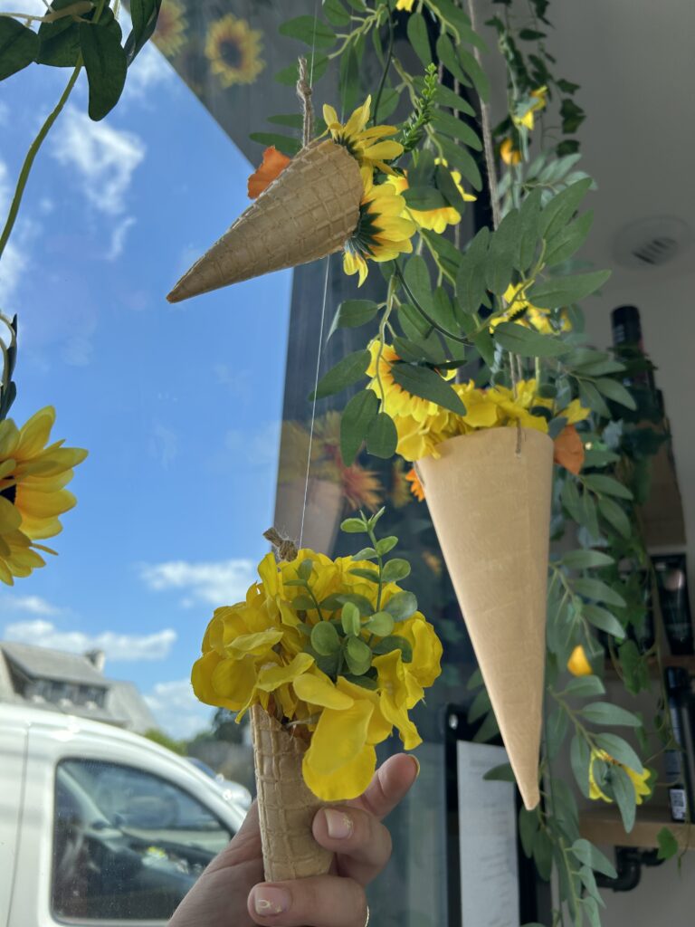 décor de vitrine pour lété avec des fleurs et des cornets de glaces
